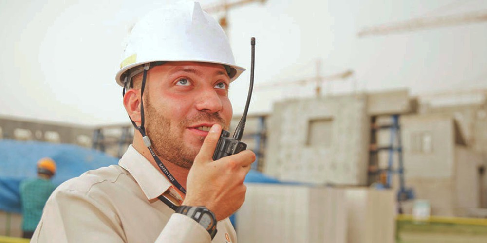A dedicated on-site worker communicating via walkie-talkie