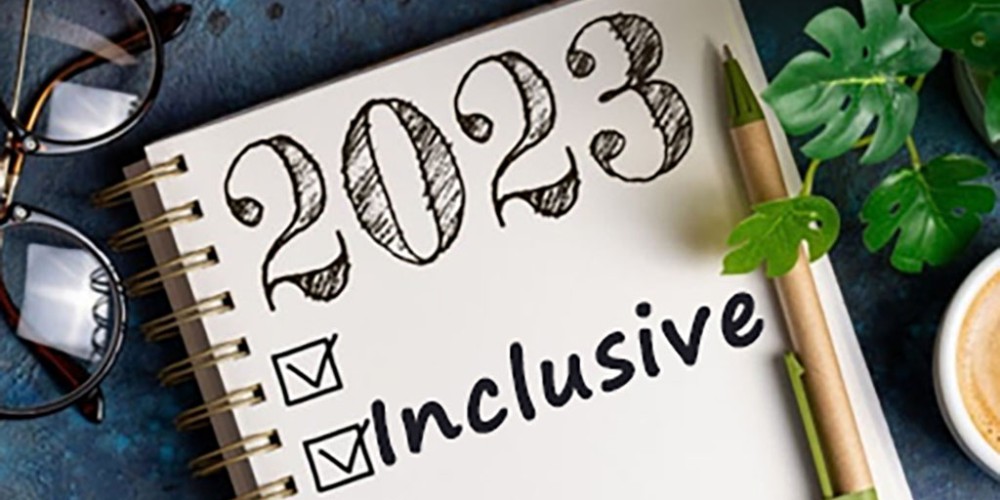 Elegant 2023 diary: '2023 Inclusive' at center, pen, and spectacles, symbolizing New Year's inclusivity resolution