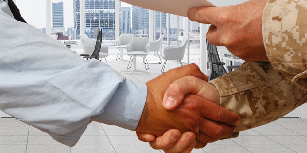  An employer shaking hand with a veteran showing how hiring veterans can benefit your business